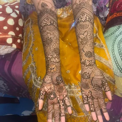 A classic full-arm bridal design with dense, interwoven patterns. Every inch is filled with detail, from the fingertips to the elbow, featuring floral vines and traditional Indian mehendi art.