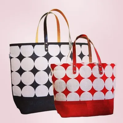 Our premium totes are available in multiple sizes and color combinations, as seen with this black and red set. We equip these bags with high-quality faux-leather handles, offering a sophisticated finish for brands seeking a fashionable accessory.