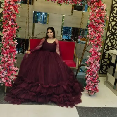 A client looking absolutely stunning in a wine-colored ruffled ball gown. This gown is perfect for making a grand entrance at a reception or sangeet.