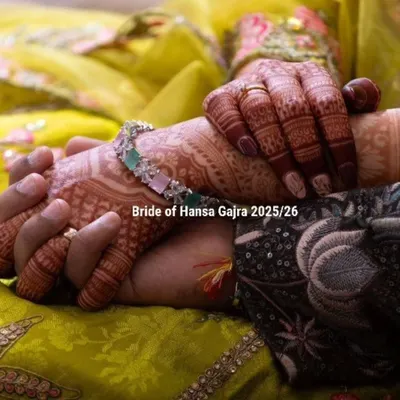 A beautiful shot of a bride's hands with colored mehendi, designed to complement her yellow and green outfit. The added color brings a modern charm to the traditional floral patterns.