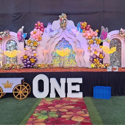 A beautiful first birthday setup featuring our large 'ONE' marquee letters. We also provided the custom-built decorative cart and butterfly props to match the whimsical theme of the event.