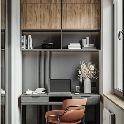 This design showcases a sophisticated home office in a narrow space, using a monochrome grey palette with warm wood accents. The vertical fluted paneling adds texture, while the overhead cabinets provide sleek, handleless storage.