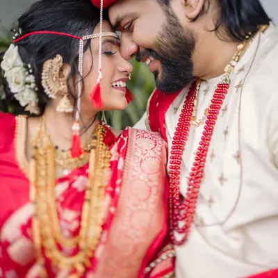 The story is in the small, silent conversations. This candid photograph captures the pure joy and intimacy of a newly married couple, focusing on their smiles and the gentle touch that says everything. It's a perfect moment from a beautiful Maharashtrian wedding.