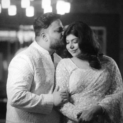 A tender moment from a Roka ceremony, captured in classic black and white. The groom's gentle kiss on her forehead and their close embrace speak volumes about their love story.