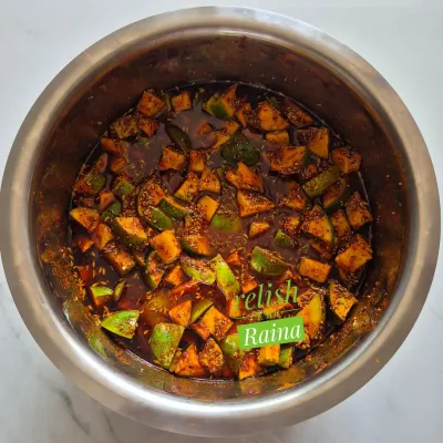 This is my Spicy Khatti Kairi pickle, made in the traditional North Indian style. I use small, regular-sized raw mangoes and a robust mix of spices like mustard seeds, fennel, and fenugreek in mustard oil. The bright red colour comes from pure Kashmiri red chilli powder, with no artificial colours added.
