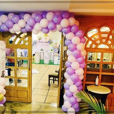 A beautiful balloon archway in purple and white creates an inviting entrance for a butterfly-themed birthday party. It sets the tone for the celebration right from the door.