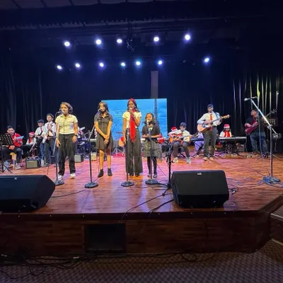 A full stage view of our band during a live concert. With multiple lead singers and a complete instrumental section, we can handle large venues and deliver powerful performances that get the crowd engaged for any corporate party or festival.