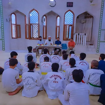 Students listen attentively during a belt distribution ceremony held at the Umar Bin Al-Khattab Masjid, a moment of shared respect and learning.