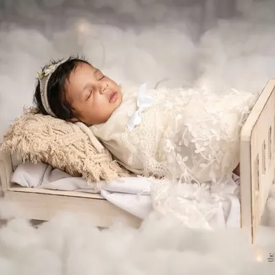 Drifting into the sweetest dreams. This newborn is nestled in a tiny wooden bed surrounded by soft clouds, a perfect example of my safe and creative fine art setups.