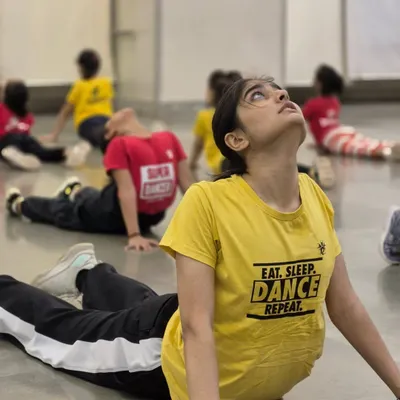 A student performs a cobra stretch during a warm-up session. Proper conditioning and stretching are mandatory in our classes to prepare the body for aerial work and prevent injuries.