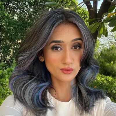 This is a beautiful blend of ash, lilac, and blue shades. The cool tones work together to create a unique and modern look, with face-framing pieces that highlight the client's features.