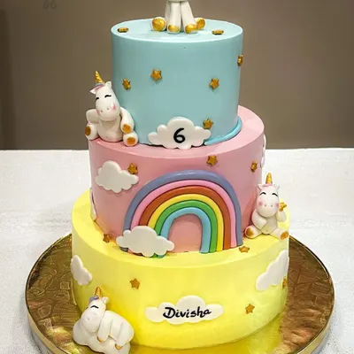 Our first three-tier whipped cream cake, made for our daughter's sixth birthday. This pastel unicorn cake was designed to match her dress, featuring four unique fondant unicorns and a beautiful rainbow.