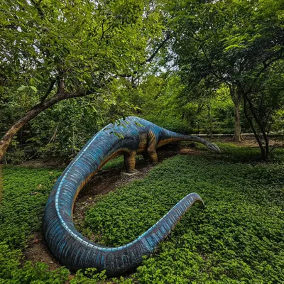 A dinosaur statue reclaimed by nature, shot on a Google Pixel. This image is a fun blend of human creation and natural beauty, highlighting the power of mobile photography.