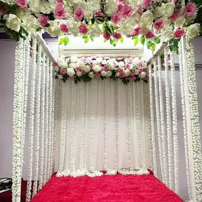 An elegant floral mandap designed for a home Ganpati celebration. We used a canopy of white and pink flowers with hanging floral strings to create a divine space for the idol.