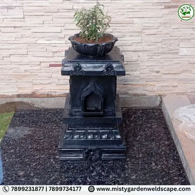 As part of a backyard makeover, we installed this traditional black stone Tulsi Katta, creating a sacred and beautiful focal point against a natural stone wall.