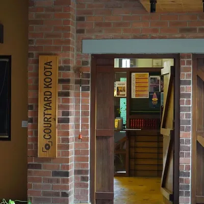 The entrance to our performance space. The wooden sign and exposed brick wall welcome you into our intimate black box theatre, a space designed for stories and connections.