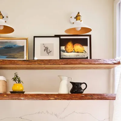 Even utility spaces can have beautiful details. For this area in the 'Breeze Home', I used live-edge wood for the open shelves, adding a rustic and organic touch. The shelves are styled with art and ceramics to make the space feel special.