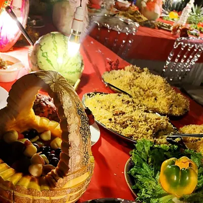 This is my special Mutton Biryani, a true bequest of paradise. You can see the long-grain rice, succulent pieces of mutton, and the beautiful presentation with fruit carvings. It's the star of any *shadikakhana*.