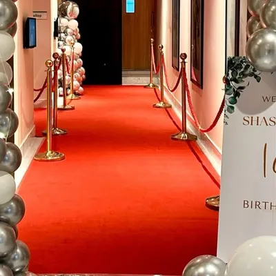 A glamorous entrance for an 18th birthday party. We rolled out the red carpet and lined it with velvet ropes and silver and white balloon columns to give guests a VIP welcome.