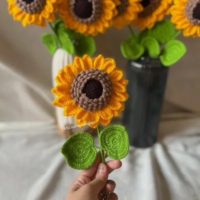 A single, handcrafted 3D crochet sunflower held in hand, showcasing its detailed petals and vibrant colors. These are perfect as a single stem or as part of a larger bouquet.
