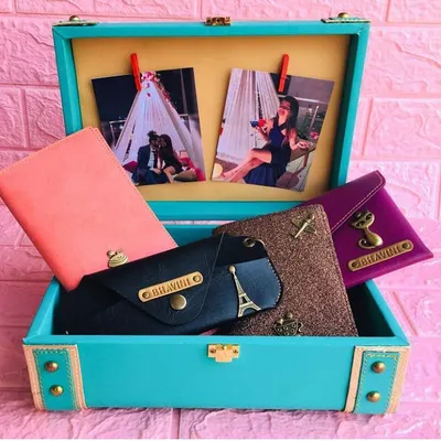 A travel accessories hamper I customized for a client, packed in a beautiful turquoise trunk. It includes personalized passport covers and wallets, with photos clipped inside for an extra personal touch.