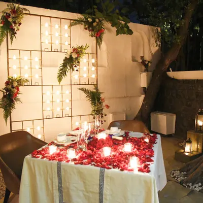 A table for two, set with a wall of candles and scattered rose petals. This is a space I prepare for those looking for a truly private and romantic dining experience.