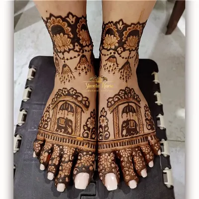This intricate foot design features majestic elephants within ornate arches, surrounded by delicate floral patterns and hanging jhumka motifs.