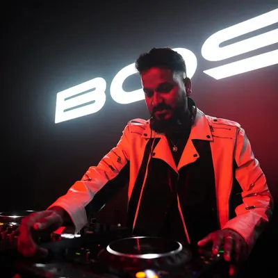 A powerful shot of me mixing under the stage lights with my name in the background. This captures the professional and branded experience I deliver.