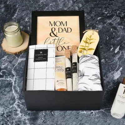 A special gift for the new family. My signature 'New Parents' hamper includes pampering products for mom and dad, a sweet wooden frame, and a little something for the baby.