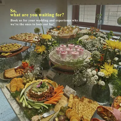 A beautiful grazing table set for a wedding celebration, featuring a variety of our gourmet offerings. This spread includes everything from savory tarts and dips to fresh fruit and floral decor, showcasing our expertise in wedding catering.