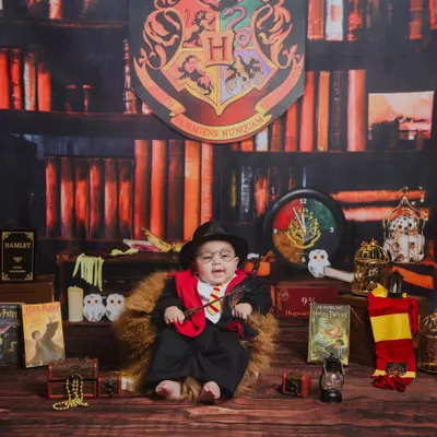 Welcome to the wizarding world. This Harry Potter themed photoshoot features a custom-built library backdrop, Gryffindor colors, and magical props to bring a touch of Hogwarts to your baby's first portraits.