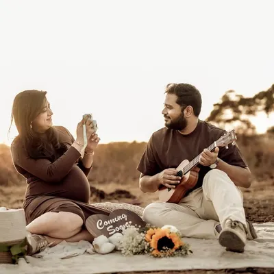 A perfect golden hour picnic. The warm light, the relaxed couple, the ukulele, and the announcement props all come together to create a dreamy, bohemian-inspired maternity scene.