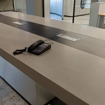 An intercom phone placed on a large conference table. Our EPABX systems ensure that every key point in your office has a reliable communication line.