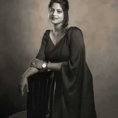 This black and white portrait of Vidyasri has a classic, timeless feel. The monochrome treatment emphasizes her confident pose and the elegant lines of her dress, creating an image of strength and grace that could have been taken in any era.