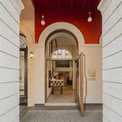 The entrance to Otoki, where the building's original colonial arches frame a simple, clean wooden door, signaling the calm and minimal aesthetic within.