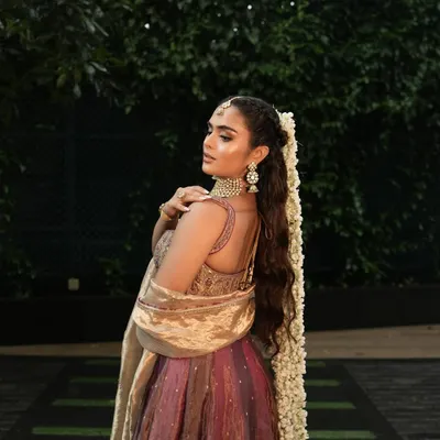 A perfect Mehendi look isn't complete without the right hairstyle. This long, wavy ponytail adorned with a gajra is elegant, comfortable, and keeps the hair off the face during the ceremony.
