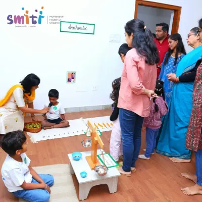 Parents and grandparents listen as a child explains a Montessori arithmetic material during our "Coconut Chronicles" science fest. We love creating opportunities for children to share their learning with family.