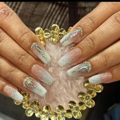 Intricate nail extensions featuring a white glitter base with large, iridescent aurora borealis crystals for a dazzling effect.