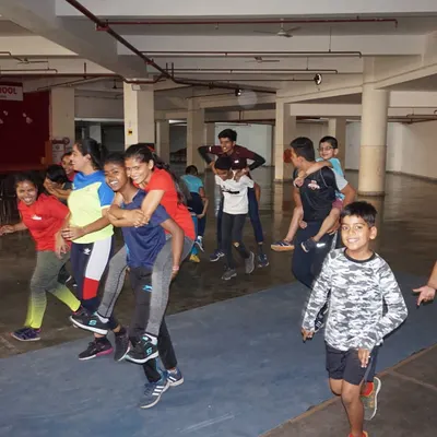 Nothing builds team spirit like a bit of fun competition. Here, our campers are all smiles during piggyback races, a favorite game at our summer camp.