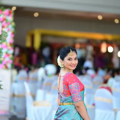 A perfect look for a wedding guest. The makeup is fresh and radiant, and the simple hairstyle lets her beautiful smile and elegant saree shine.