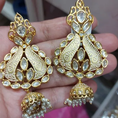 A beautiful pair of real Polki earrings with ivory-coloured meenakari work. These jhumka-style earrings are perfect for adding a touch of elegance to any ethnic outfit.