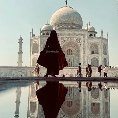 A stunning silhouette shot of me in front of the Taj Mahal with its reflection in the water. This artistic photo is a powerful piece of travel content.