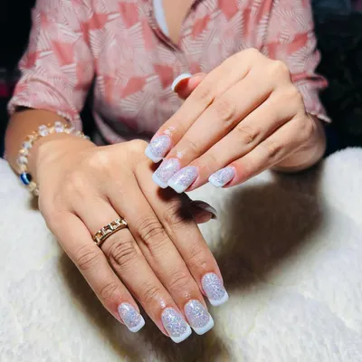 A beautiful glitter French tip on a square nail shape. This is a modern twist on a classic, combining the elegance of a French manicure with a touch of sparkle.