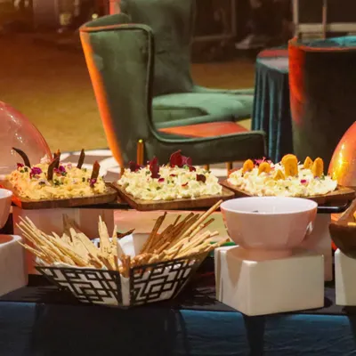 A glimpse of our buffet setup, featuring a variety of dips and breads. The presentation is rustic yet elegant, with wooden boards and stylish bowls, set against a backdrop of luxurious event furniture.