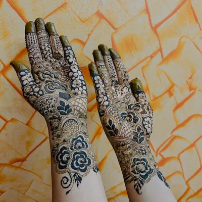A classic Indo-Arabic design where bold floral and leaf motifs create a flowing pattern. The contrast between the dark, thick outlines and the skin is a hallmark of this style.