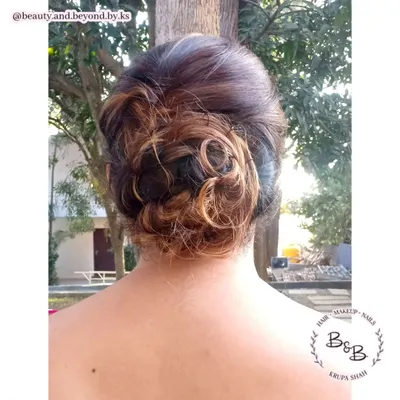 The beauty of a messy updo is in its texture. For this client, the highlights in her hair added beautiful dimension to the interwoven curls of the bun, creating a unique and modern look for her friend's wedding.