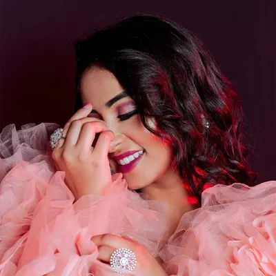 A soft and elegant close-up portrait. The gentle lighting, shy smile, and textured pink gown come together to create a glamorous and emotive image, perfect for a fashion or personal portfolio.