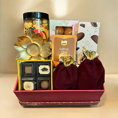 This beautiful Diwali tray is filled with festive delights, including custom-branded chocolates, saffron chai, gourmet popcorn, and a decorative tea light holder.