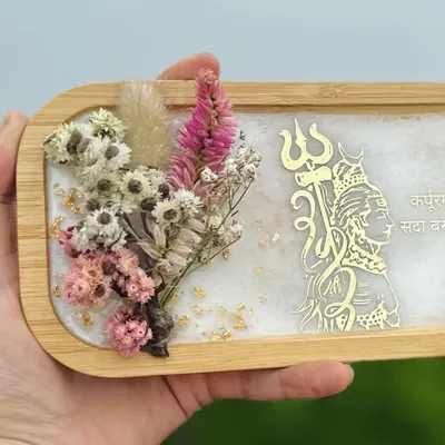 ॐ नमः शिवाय. This is one of my favorite pieces, a decorative wooden tray with a resin art inlay. It features a golden Shiva trishul, dried flowers, and a sacred mantra. It's perfect for your home temple or as a thoughtful gift.
