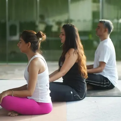 I believe in providing personal attention to ensure you feel safe and supported. Here, I am offering a gentle adjustment to help a student find more ease and correct alignment in a seated pose.